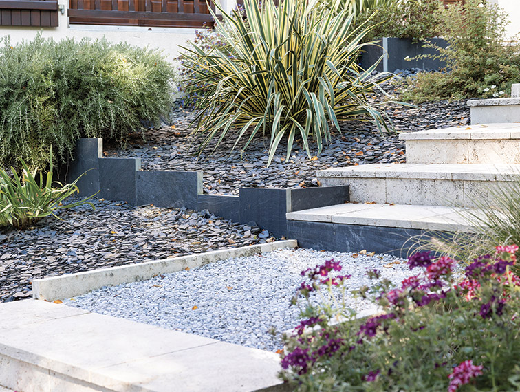 Accès par un escalier bordé de graviers et de massifs de fleurs