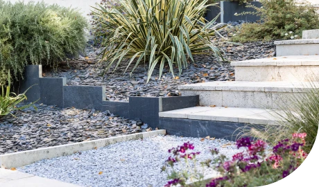 Accès par un escalier bordé de graviers et de massifs de fleurs
