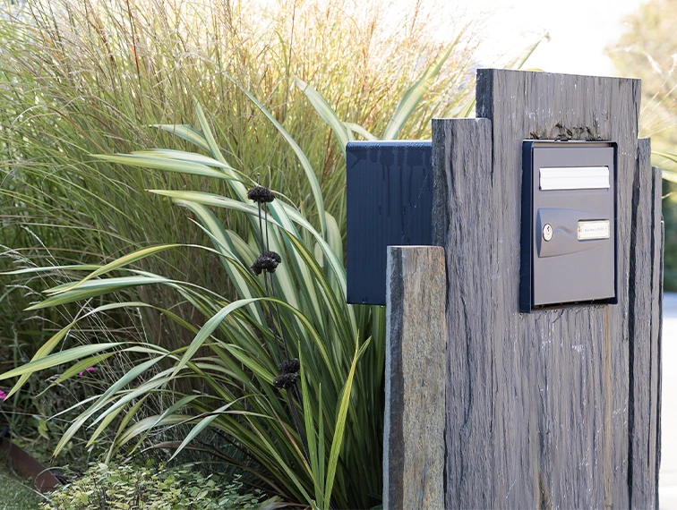 Haie mixte végétalisant l'entrée de la maison, clôture intégrant la boite aux lettres